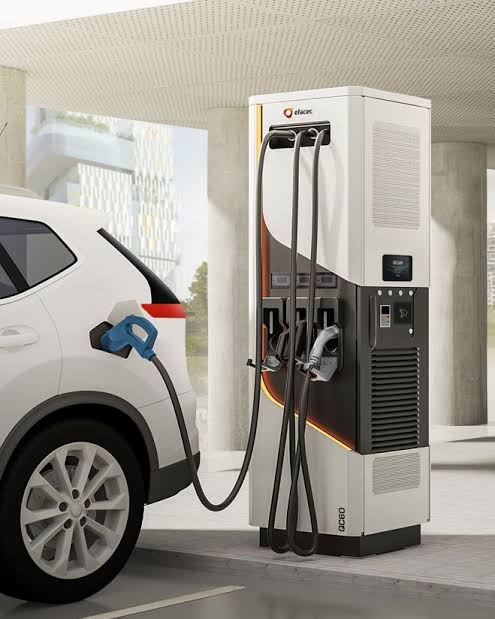 Illustrative DC charger and electric car at a destination location